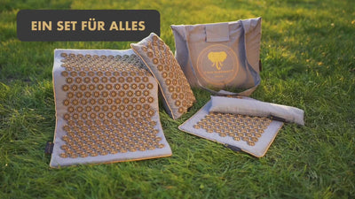 Akupressurmatte | GENUINE 5er Set - beige mit Massagematte und Tasche auf grünem Gras.